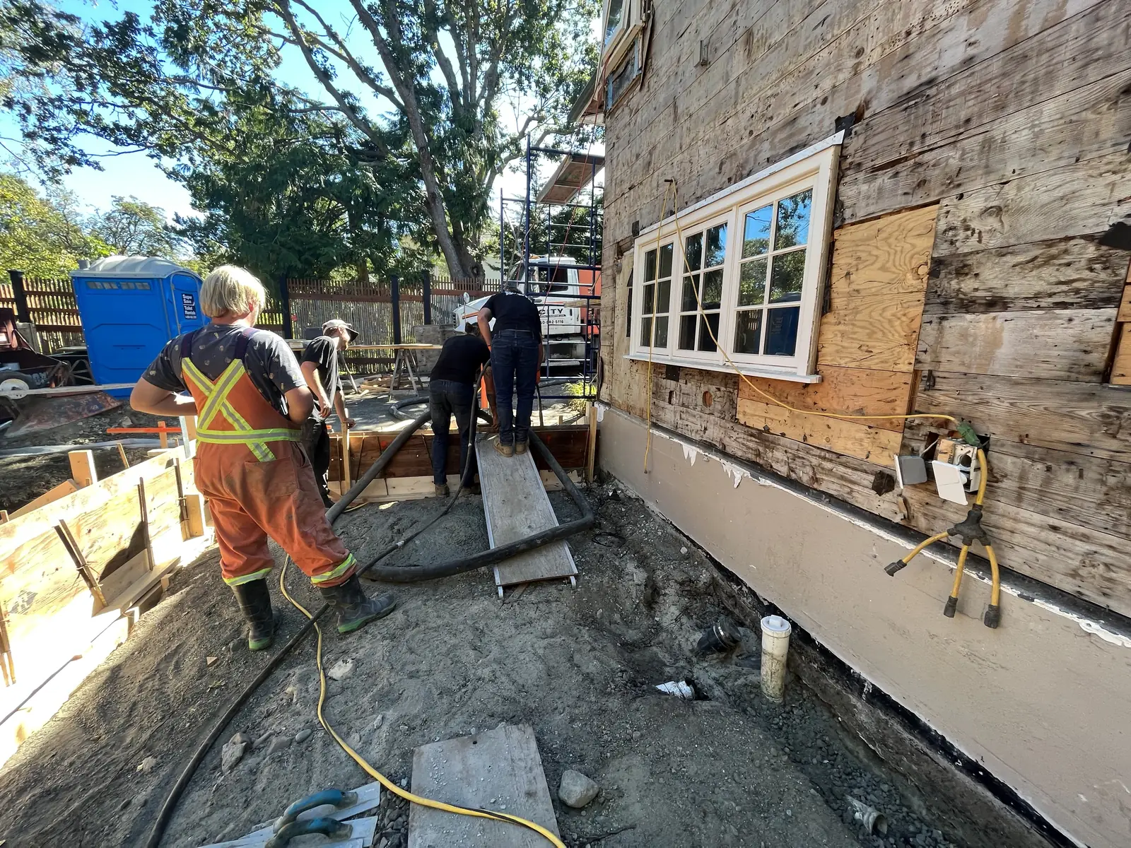 Crew working along a foundation and exterior wall