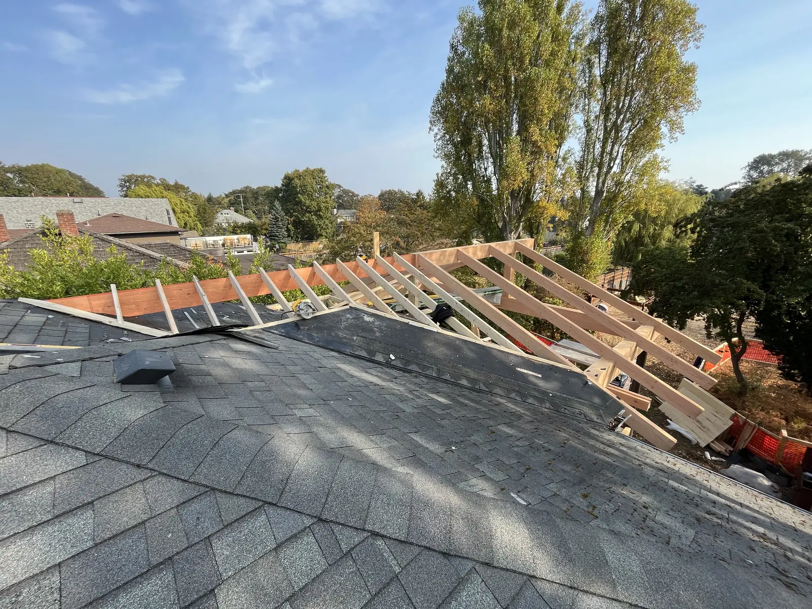 Roof sheathing being laid with a ladder against the eave
