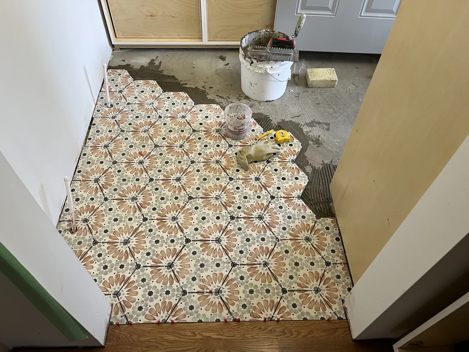 Patterned tile floor meeting the wall during finishing
