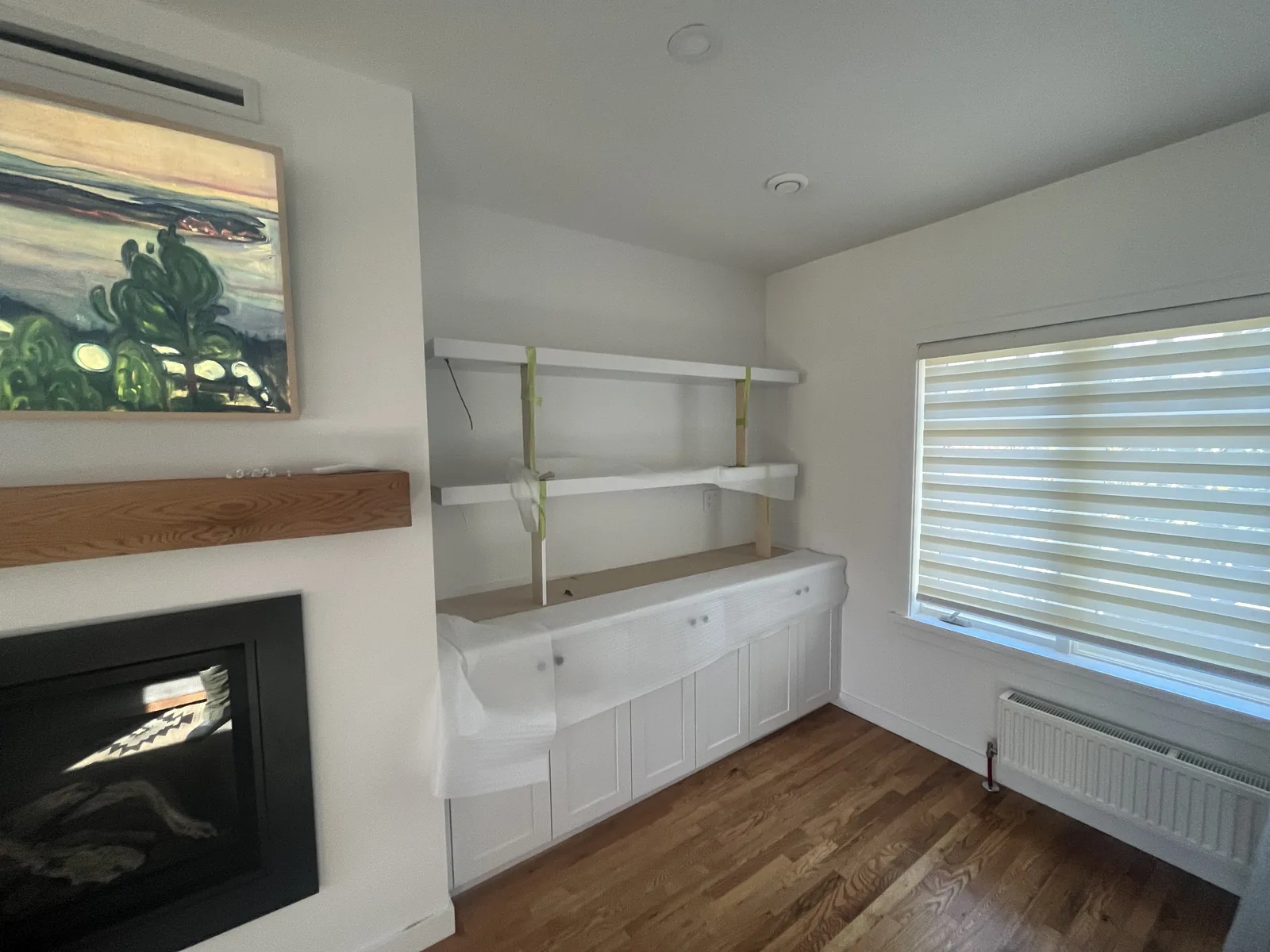 Fireplace with white built in shelving in a finished room