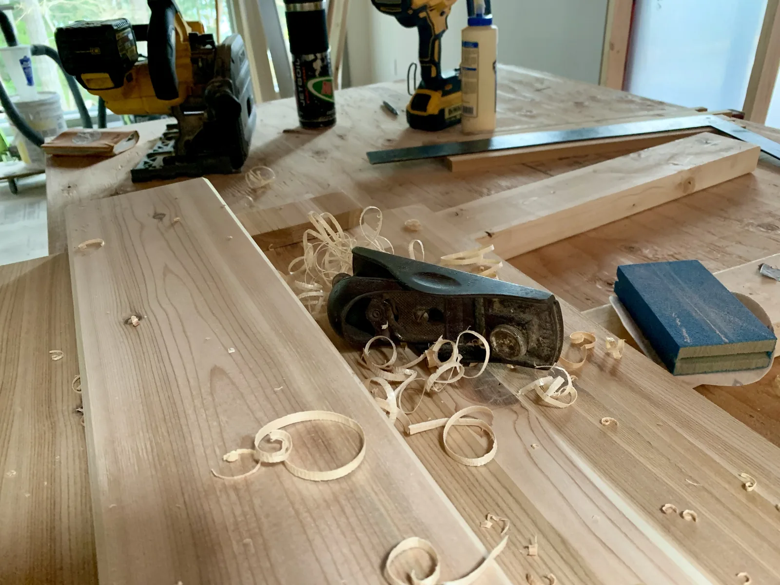 Timber being planed on a workbench with shavings