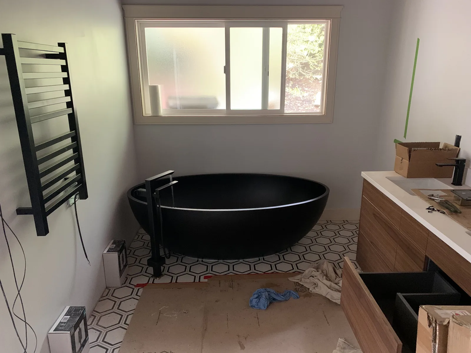 Bathroom with a black freestanding tub and a vanity under construction