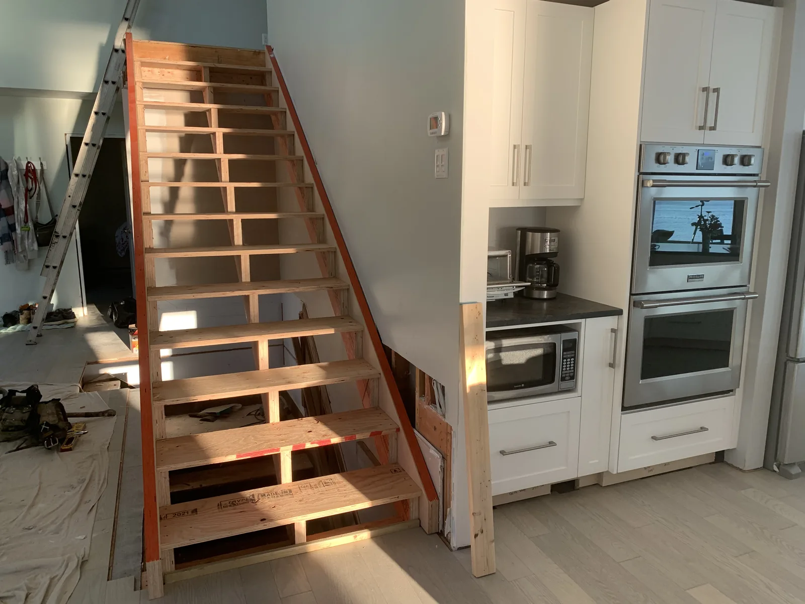 Open riser wood stair beside a new kitchen