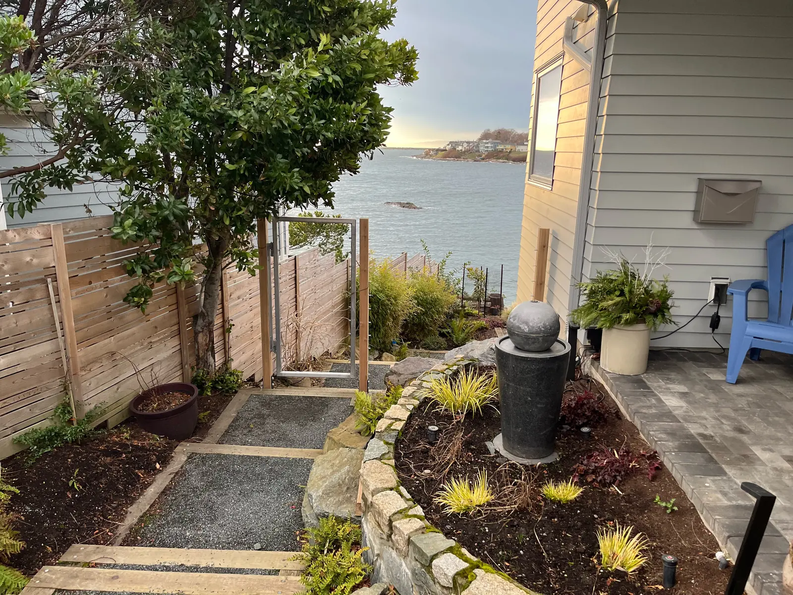 Landscaped garden path with paving stones, planting beds and a water feature