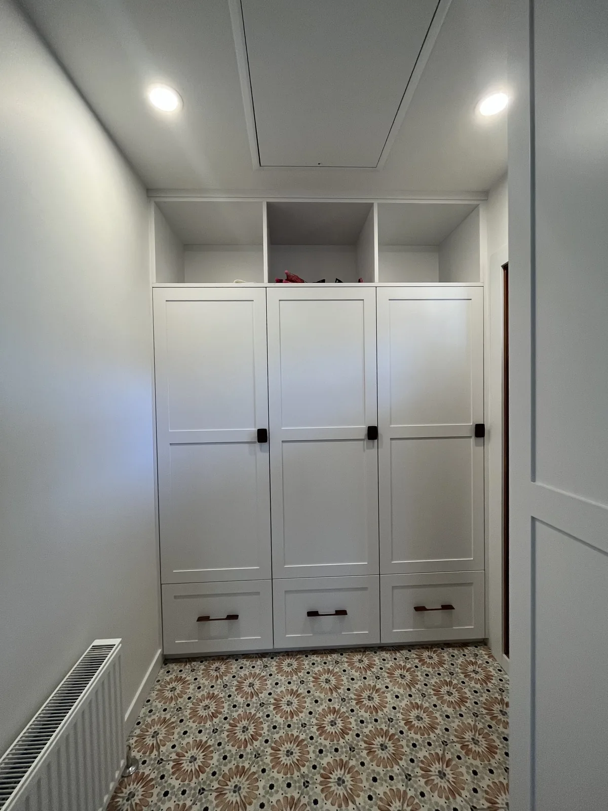 Floor to ceiling white built in cabinetry along a hallway