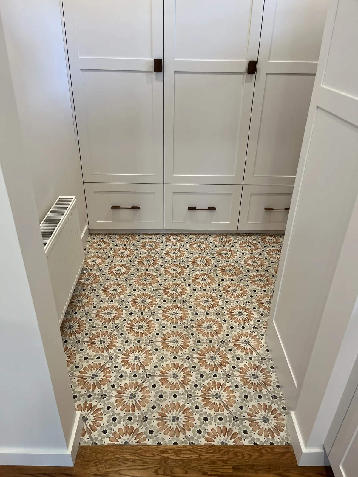 White built in cabinetry above a patterned encaustic tile floor