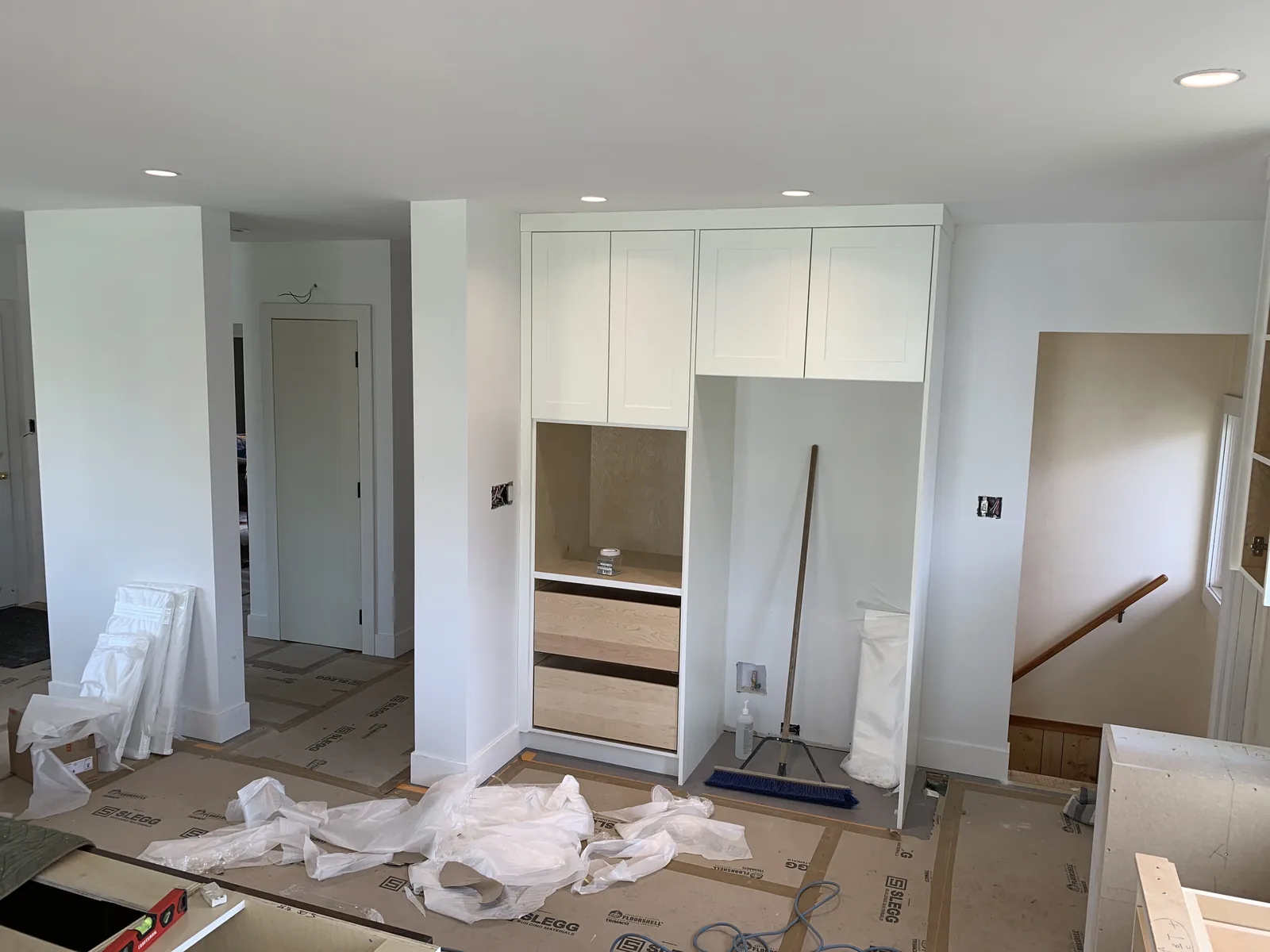 White cabinetry and a doorway at the finishing stage of a renovation