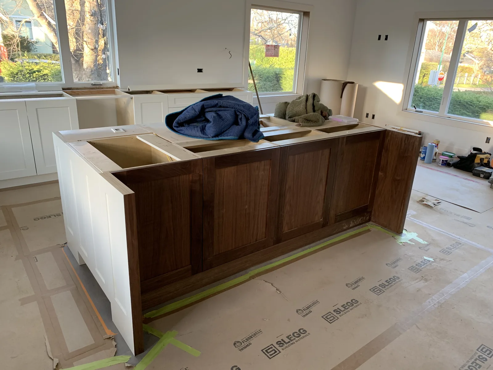 Walnut island under construction with the floor protected