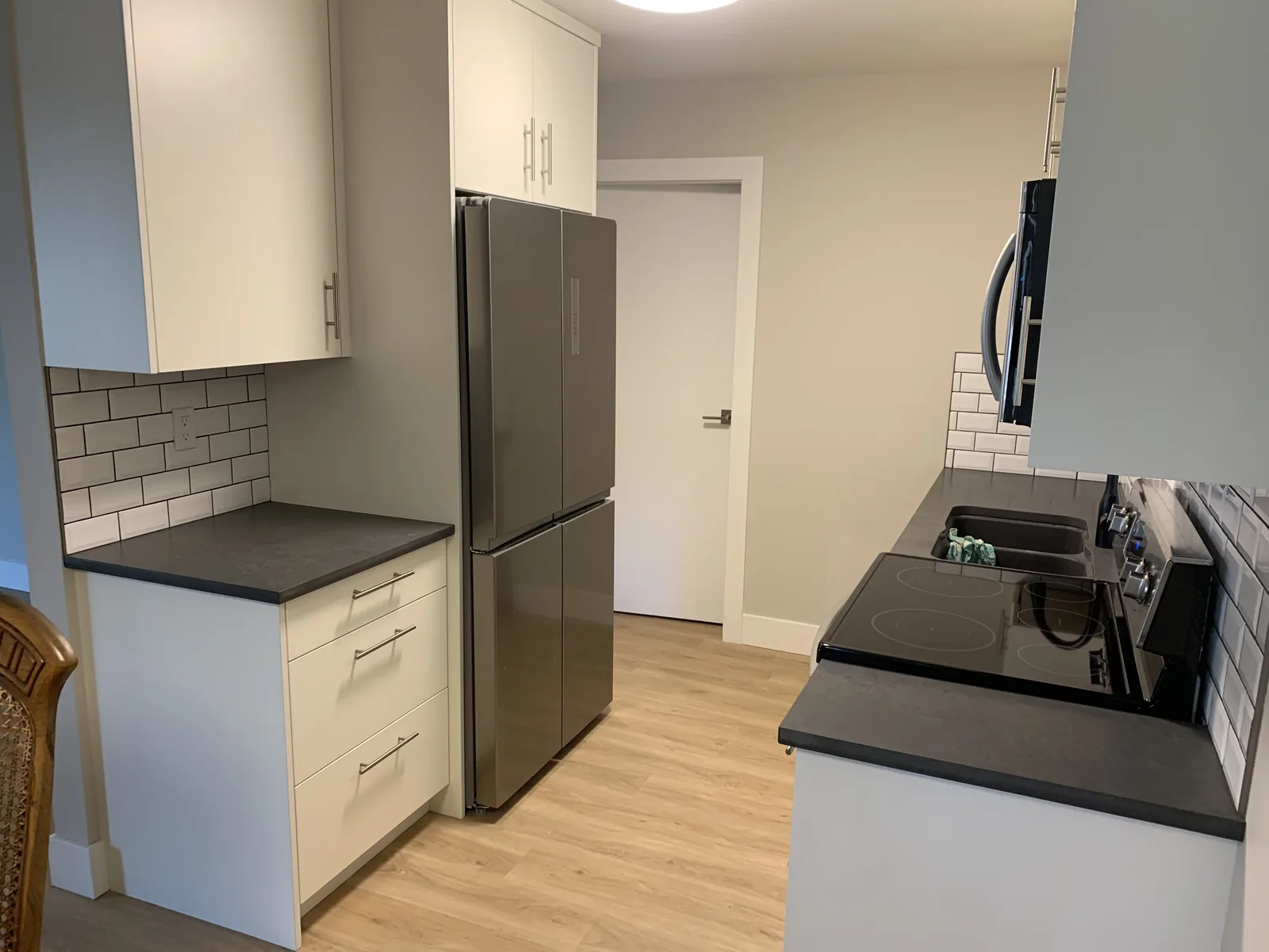 Kitchen corner with a stainless fridge and a dark countertop