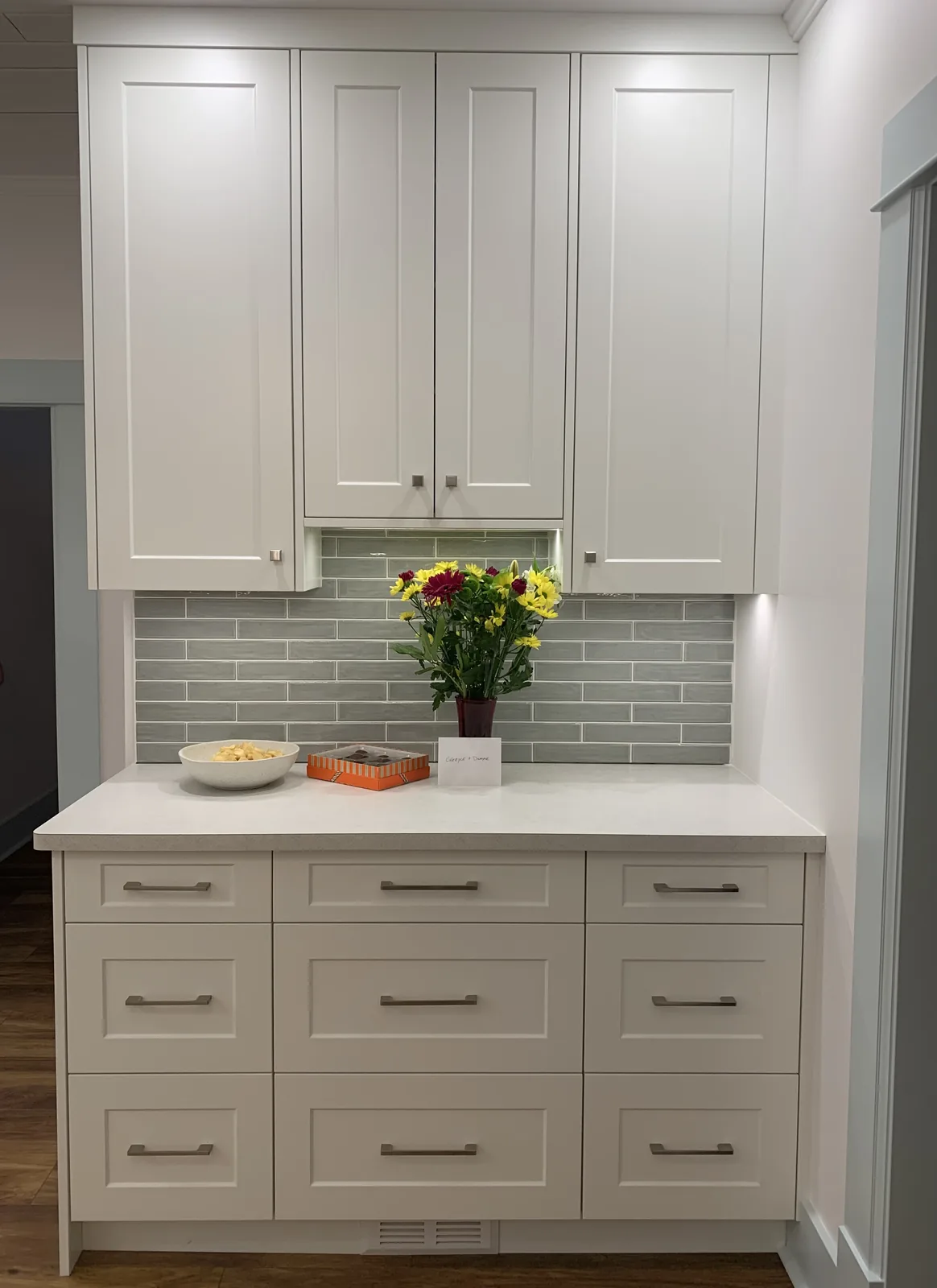 White vanity unit with a green tile backsplash