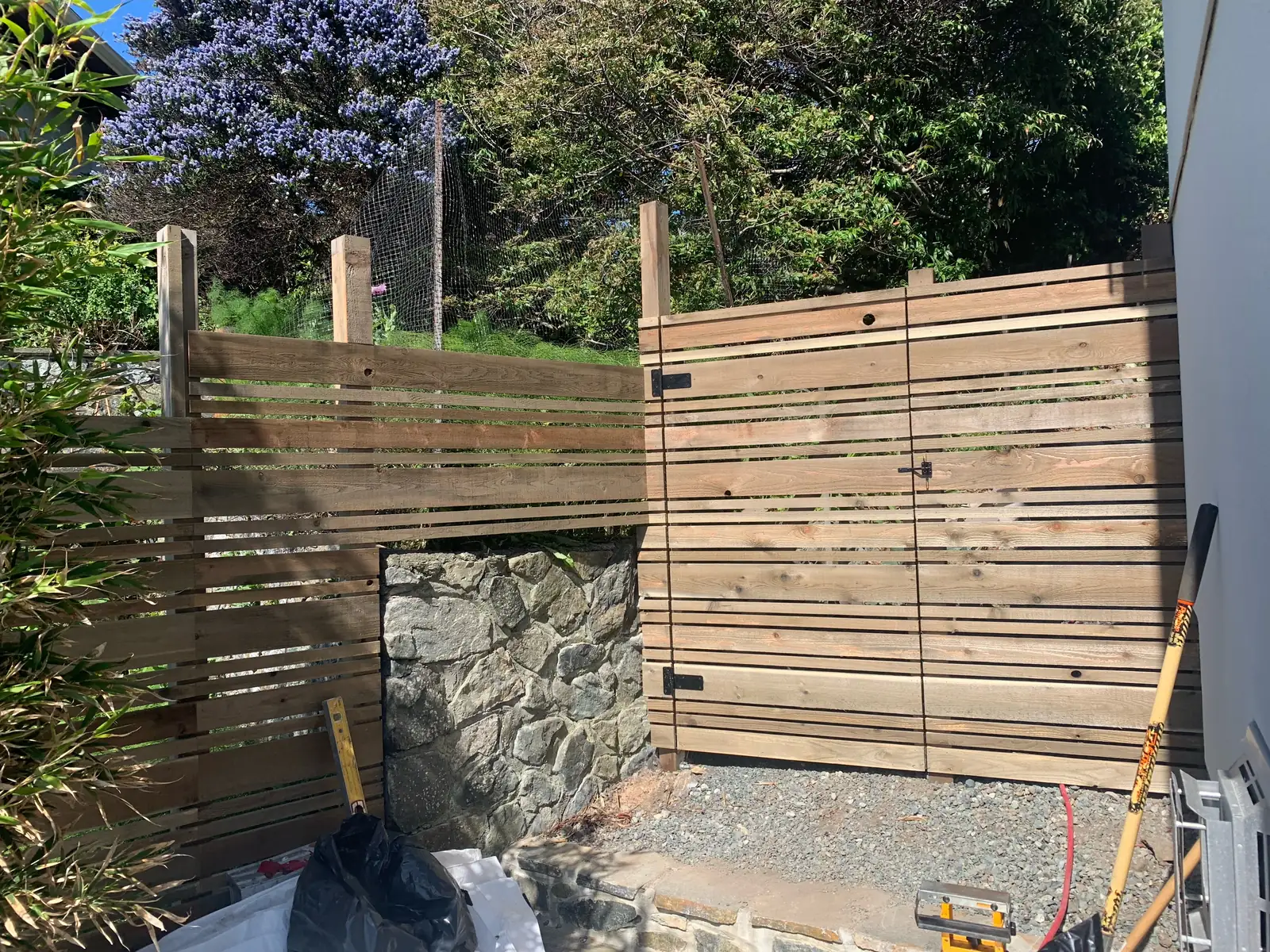 New horizontal cedar slat fence under construction
