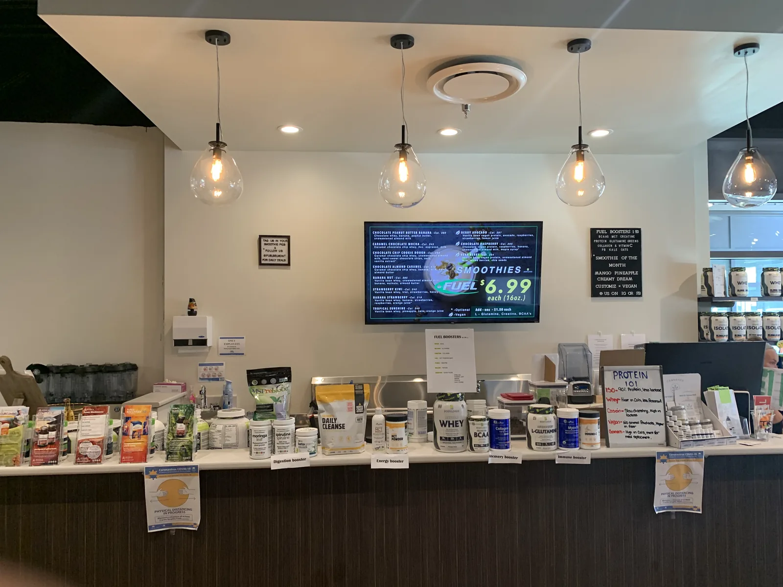 Service counter with pendant lighting and a menu display screen at Fuel SVN