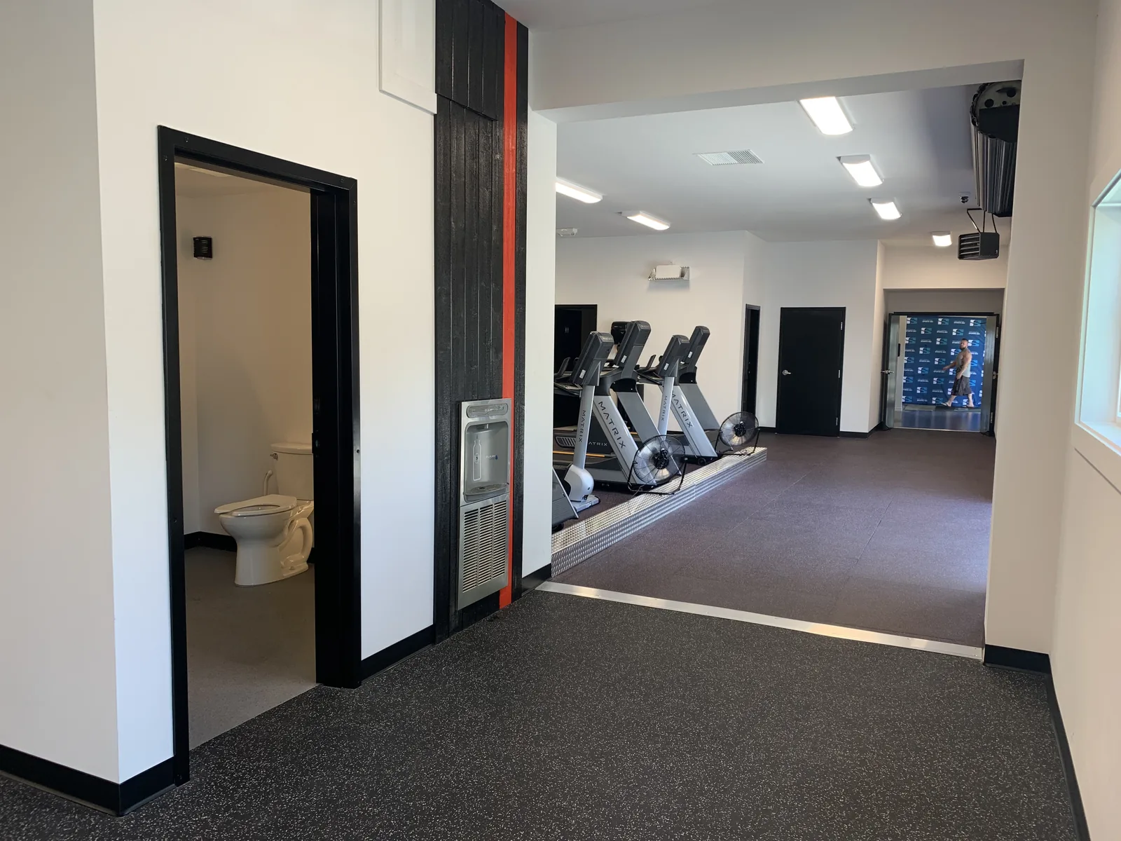Corridor with black framed doorways leading to the washrooms at Truth Gym Victoria